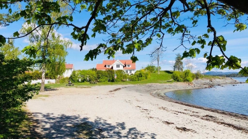 Strand med et hvitt hus ved Oslofjorden