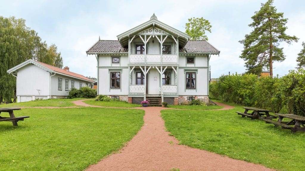 Hus i sveitservillastil med plen og gangvei foran