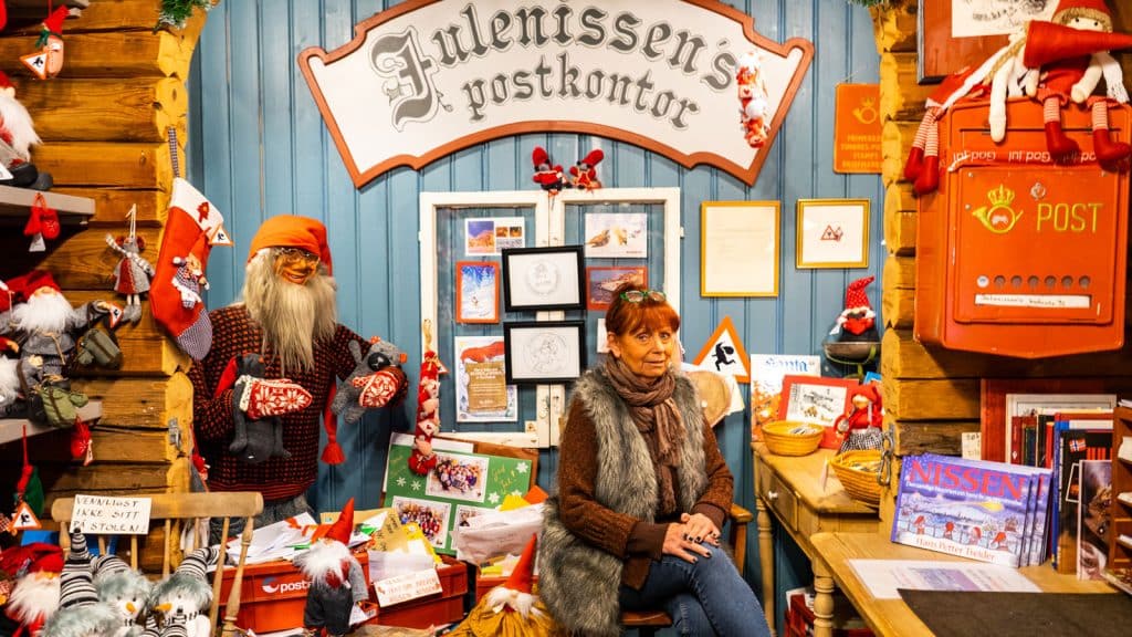 Julenissens postkontor med en dame som sitter på en stol