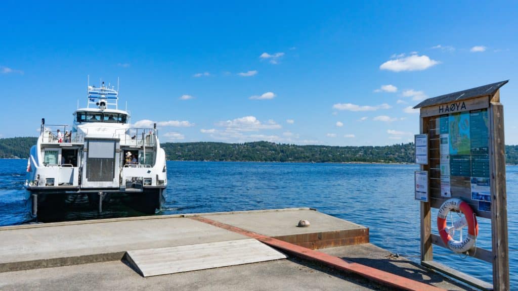 Ruterbåt som tar av fra kai i fjord