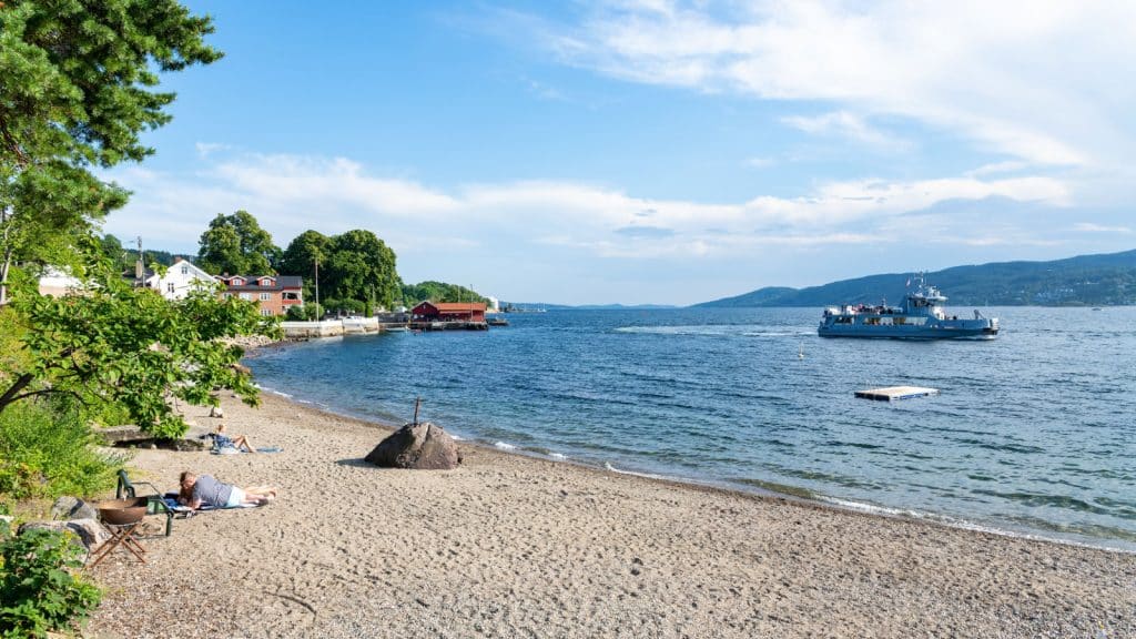 Beach and ferry and fjord on a summer day