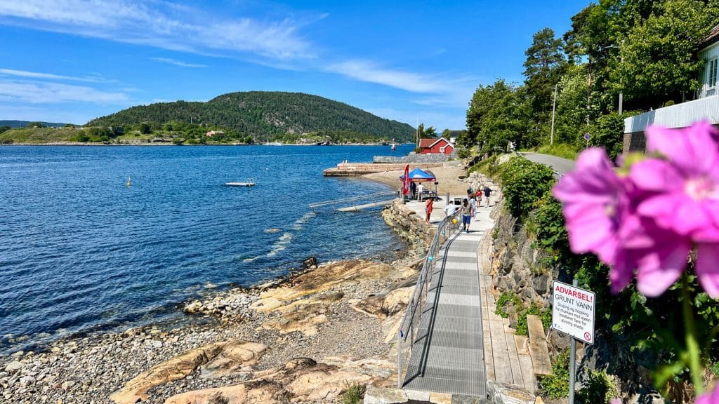 Beach with wheelchair ramp with fjord in the background and rocky beach
