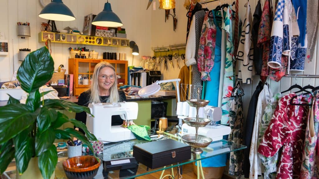 Dame ved symaskinen i en butikk