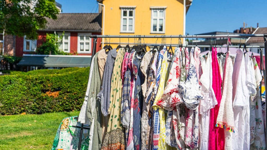 Tunikaer og skjorter på et klesstativ på et torg