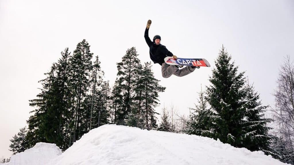 Snowboarder som hopper i en snowboardbakke