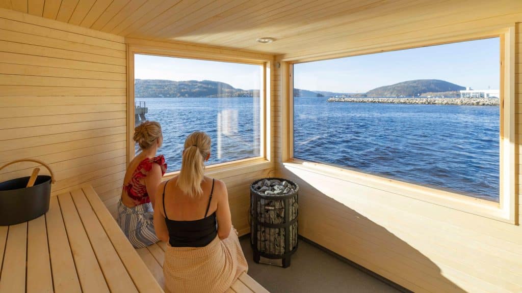 To damer sitter i badstue og nyter utsikten