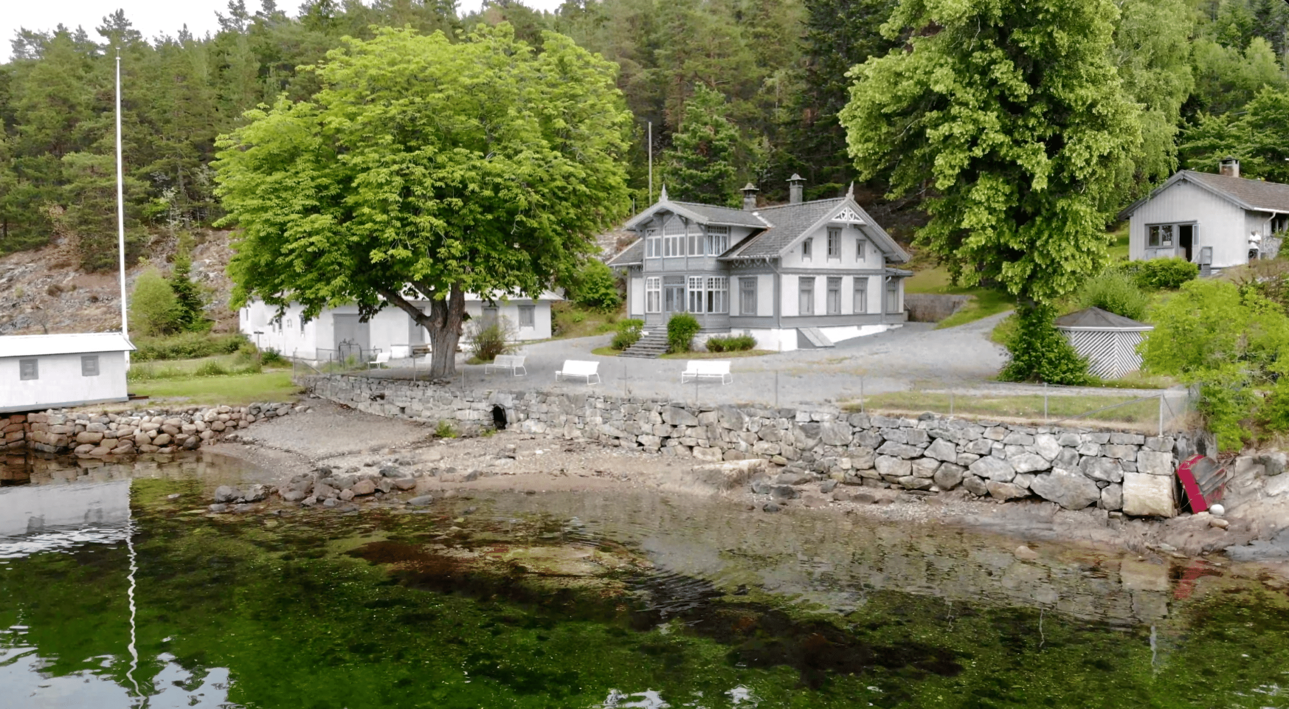 grått hus ved oslofjorden med strand